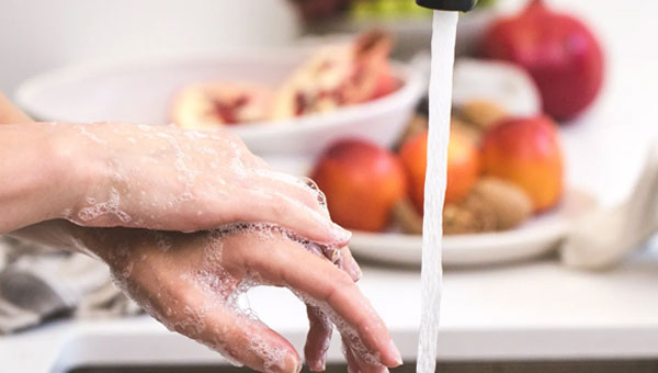 Personne en train de se laver les mains après avoir effectué la vaisselle