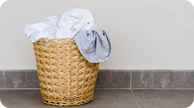 panier à linge plein devant une machine à laver Autodose